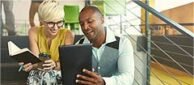 African male office executive showing mobile applications to a female executive